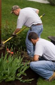 two of our Sachse irrigation repair specialists are fertilizing the flower beds