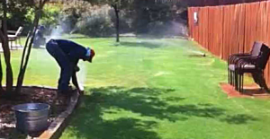 a Sachse sprinkler repair specialist is adjusting a pop-up head